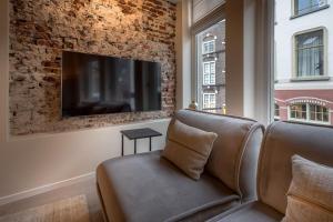ein Wohnzimmer mit Couch und Flachbildfernseher in der Unterkunft Luxe Herenhuis Huis68 in de binnenstad van Zwolle in Zwolle
