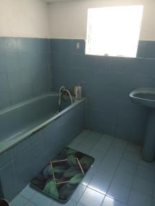 een badkamer met een bad en een wastafel bij La rose des Bois in Saint-Louis