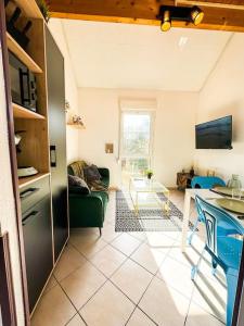 een keuken en een woonkamer met een bank en een tafel bij NEW Le Duplex au Coeur de Ville PARKING Privé in Guingamp
