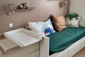 a bed with pillows on it in a room at Appartement T3 calme avec jardin privatif in Pontoise