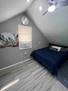 1 dormitorio con 1 cama y reloj en la pared en 1 Bed Room Apartment near Airport, en Hillside