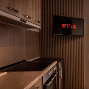 een keuken met een netflix-bord op de muur bij Suprem Apartment Modern Studio Near City Center, Self Check-in & Fast Wi-Fi in Tirana +3 foto's