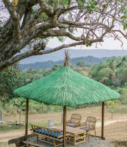 a table and chairs under a green umbrella at Dome tent in Elyu will Pool Access for 10 pax 