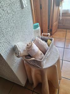 a basket with towels and a cup and a wall at Hostal el patio restaurante in San Bartolomé de Pinares