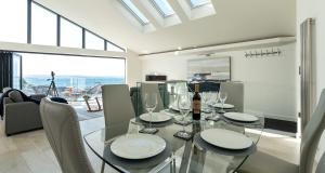 ein Esszimmer mit einem Glastisch mit Weingläsern in der Unterkunft High Seas - NEW LISTING in Brixham