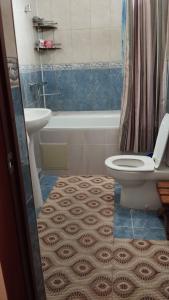 een badkamer met een toilet, een bad en een wastafel bij Дом in Prigorodnoye