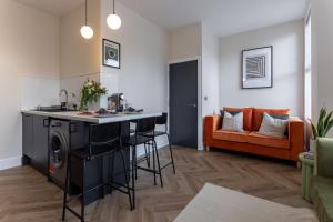 a kitchen and living room with a bar and a couch at Broughton Place: Contemporary Apartments in Liverpool in Liverpool