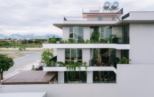 a white building with plants on the balconies at Peaceful Retreat Seafront Villa Da Nang in Da Nang