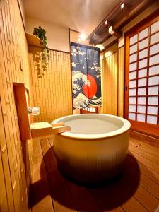 Habitación con baño con bañera grande. en Karin House, en Takayama