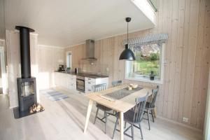 a kitchen and dining room with a table and a stove at Cabin in Lofoten with spectacular view in Ballstad