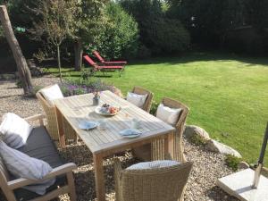a wooden table and chairs in a garden at StrandGlück in Kleinwaabs