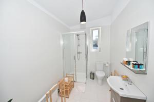 a white bathroom with a shower and a sink at MIRA by Atra in Teşila
