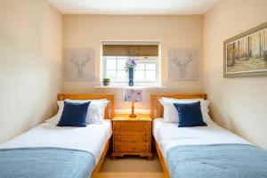 two twin beds in a room with a window at Croft House Sleeps 8 ꕤ Country Views nr Salisbury in Salisbury