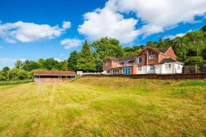 a large house on top of a grass field at Croft House Sleeps 8 ꕤ Country Views nr Salisbury in Salisbury