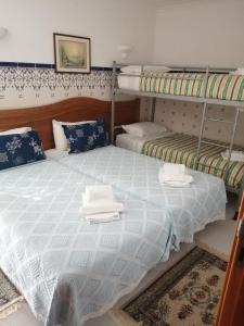 サン・マルティーニョ・ド・ポルトにあるHotel Atlânticaのベッドルーム1室(二段ベッド2組、タオル付)