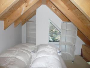 ヴェスターラントにあるHaus-Hookipa-App-2のベッドルーム(白いベッド1台、本棚付)