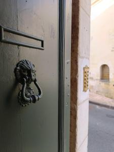 Maison Charmeilles - Gîte touristique - Coliving في Fronsac: باب يطرق الباب المعدني عليه