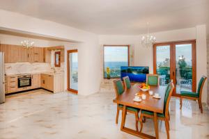 a kitchen and dining room with a table and chairs at Maroulas Natura Palace in Giannoudi