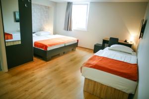 ein Hotelzimmer mit zwei Betten und einem Fenster in der Unterkunft Ambient Hotel in Domžale