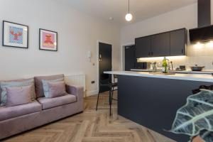 a living room with a couch and a kitchen at Broughton Place: Contemporary Apartments in Liverpool in Liverpool