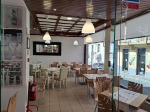 a restaurant with tables and chairs in a room at Hotel SQUARE in Sertã