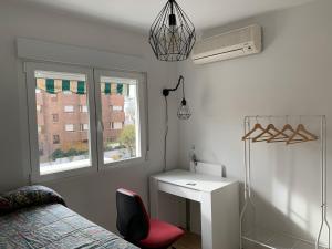 a bedroom with a bed and a desk and a window at Piso en Arturo Soria para 5 personas cerca del Aeropuerto y de IFEMA in Madrid