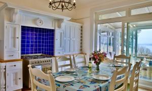een keuken met een tafel met stoelen en een eetkamer bij York Lodge West in Brixham