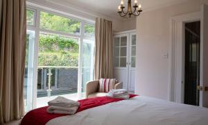 een slaapkamer met een bed met een stoel en een raam bij York Lodge West in Brixham