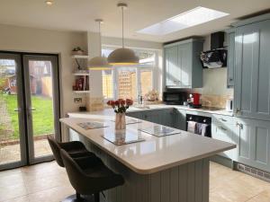 a kitchen with a large island with a vase of flowers on it at Beautiful Victorian Home near central Oxford in Oxford