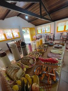una mesa con muchos tipos diferentes de comida en ella en Pousada Bela Vista en Penedo