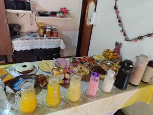 a table topped with plates of food and bottles of juice at Pousada Bela Vista in Penedo