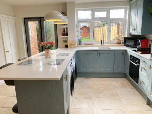 a kitchen with blue cabinets and a white counter top at Beautiful Victorian Home near central Oxford in Oxford