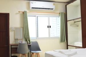 a bedroom with a bed and a window and two chairs at Chaiwat Hostel in Bangkok