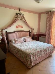 - une chambre avec un grand lit à baldaquin dans l'établissement Arca Hotel, à Pienza