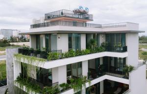 an apartment building with plants on the balconies at Peaceful Retreat Seafront Villa Da Nang in Danang