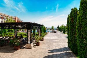 a garden with a pavilion with potted plants at Prestige Mer d'Azur in Sunny Beach