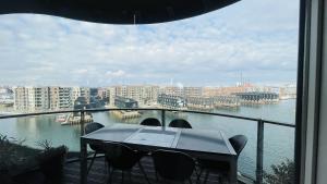 uma mesa e cadeiras numa varanda com vista para a água em ApartmentInCopenhagen Apartment 1591 em Copenhague