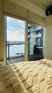 - une chambre avec un grand lit et une grande fenêtre dans l'établissement ApartmentInCopenhagen Apartment 1591, à Copenhague