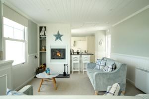 a living room with a couch and a star on the wall at Point Cottages, Bamburgh in Bamburgh