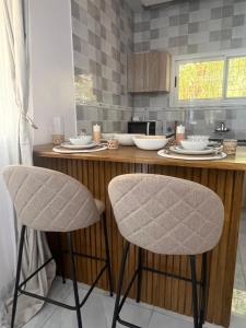 a kitchen with a counter with two bar stools at River view Kanazi in Niamey