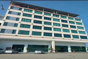 un grande edificio con macchine parcheggiate di fronte di OYO 90934 Tong Villion Hotel a Muadzam Shah