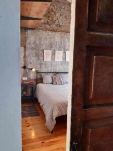 1 dormitorio con 1 cama y suelo de madera en Casa Les Indies, en Villaviciosa
