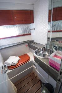 a small kitchen with a sink and a mirror at Luxury Living on a Yacht in Mýkonos City