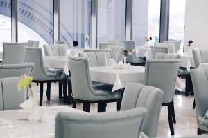 a dining room with white tables and chairs at Zaha Taiba Hotel in Medina +33 photos