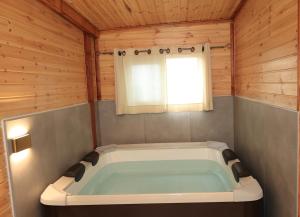a large bath tub in a room with a window at קסם עין כרם in ‘En Kerem