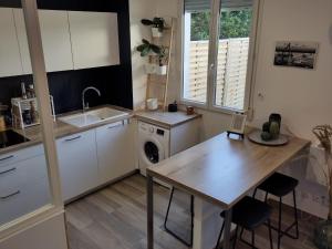 a kitchen with a table and a washing machine at Appartement T3 calme avec jardin privatif in Pontoise