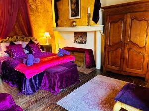 ein Schlafzimmer mit einem Bett mit violetter Bettwäsche in der Unterkunft Les Contes in Fougax-et-Barrineuf