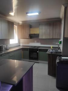 a kitchen with wooden cabinets and a stove top oven at Brand new crane Apartments in Lenasia