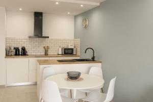 a kitchen with a white table and white chairs at Apartamento WELCS EMP-109- al lado del canal in Empuriabrava