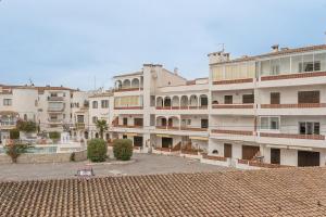 a large white building with a courtyard in front of it at Apartamento WELCS EMP-109- al lado del canal in Empuriabrava